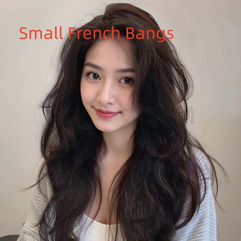 Model showcasing a small French bangs hairstyle with long curly hair in natural dark tones.
